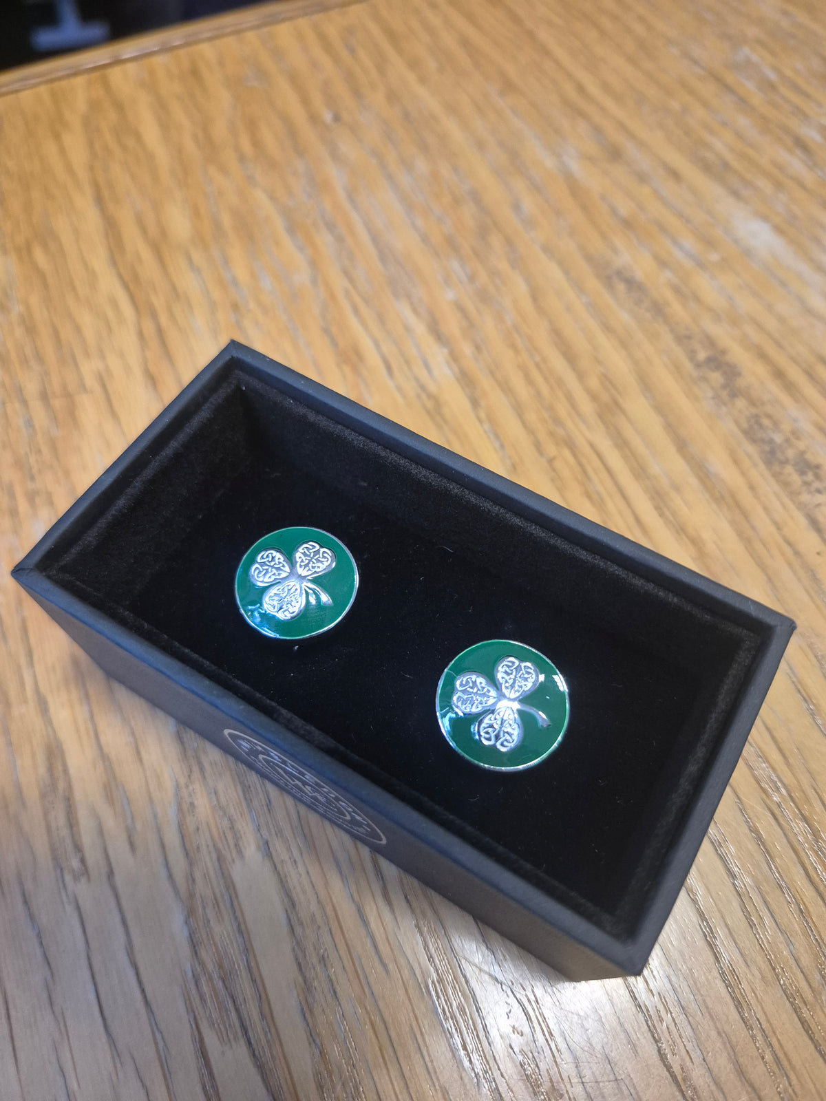 Cufflinks silver shamrock on a green background
