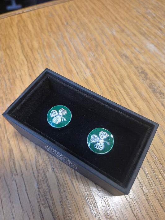 Cufflinks silver shamrock on a green background